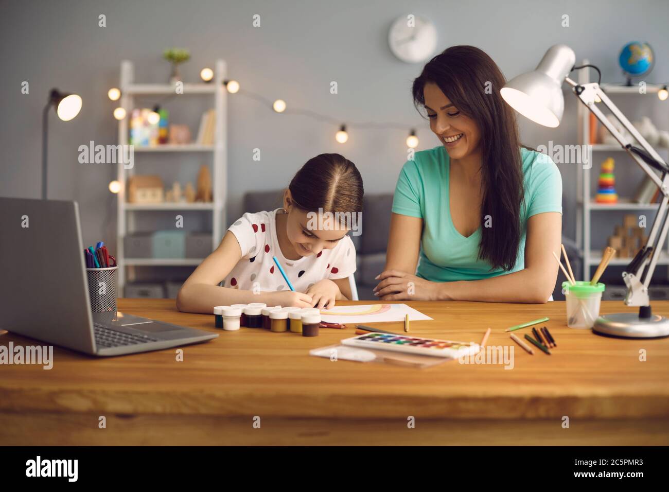 Online-Bildung von Kindern. Mutter und Tochter der Vorschule beobachten eine Video-Lektion Anruf Chat kreativen Kurs Kunst Zeichnen mit Lapott sitzen an einem Stockfoto