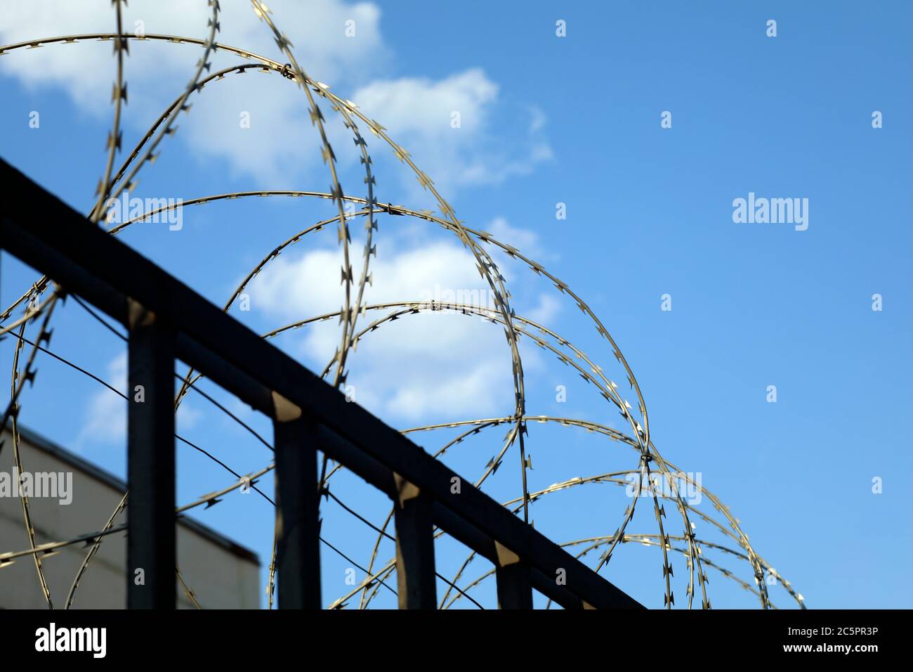 Stacheldrahtzaun der Sicherheit oder verbotene bewachte Zone auf blauem Himmel mit Cluods mit Platz für Ihren Text Stockfoto