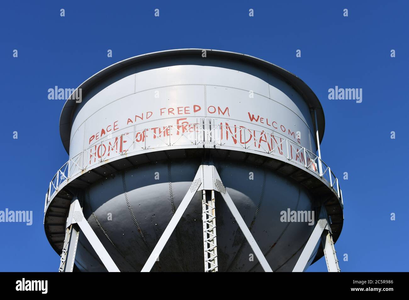 Der graue Wasserturm auf Alcatraz Island, mit roten Graffiti bedeckt. Frieden und Freiheit, Heimat der Freien, Willkommen Indianer. San Francisco, Kalifornien Stockfoto