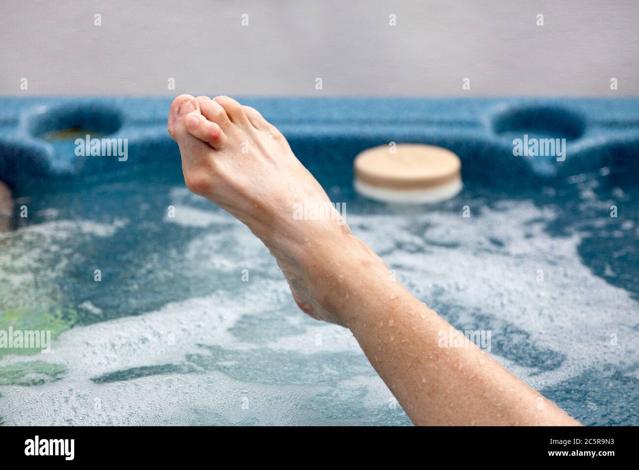 Weiblicher Fuß im Whirlpool mit Knochendeformitäten: Bunions und Hammerzehen. Horizontal. Stockfoto