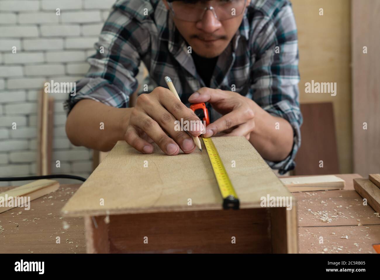 Zimmermann arbeitet an Holzarbeiten in der Werkstatt Stockfoto