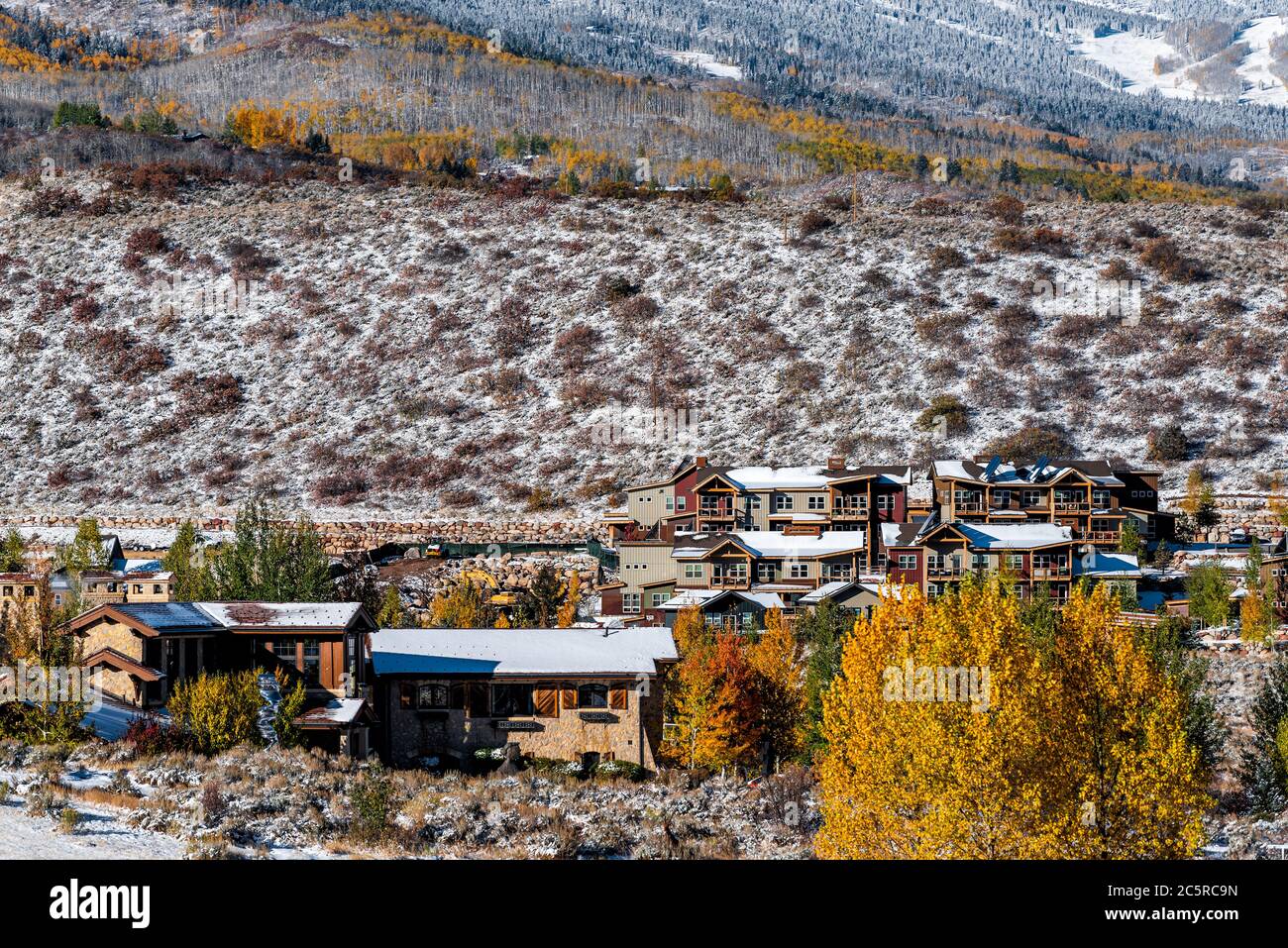 Aspen, Colorado felsige Berge mit Häusern, die nach dem Winter mit gelben Herbstbäumen und Stadtbild bedeckt sind, moderne Skiresort-Lodge-Stadt Stockfoto