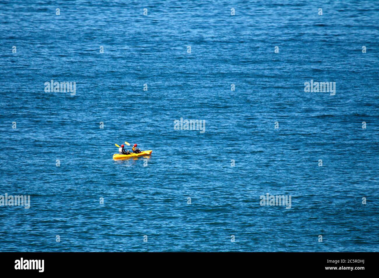 Zwei Personen tragen rote Helme in Yellow Sea Kayak Stockfoto