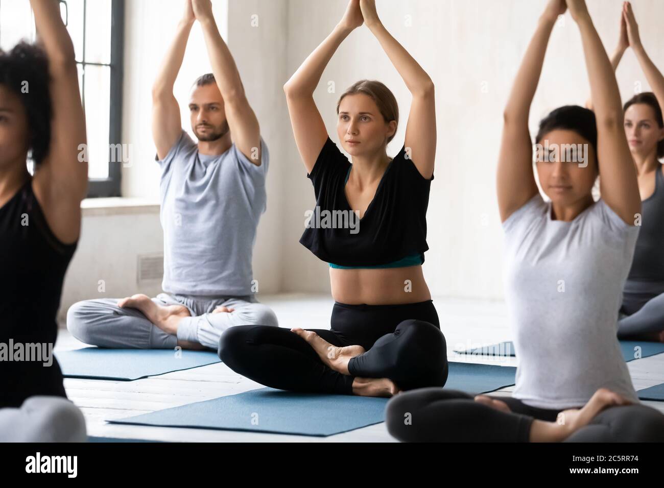 Junge europäische Erscheinung Frau, die Gruppe Yoga-Klasse. Stockfoto