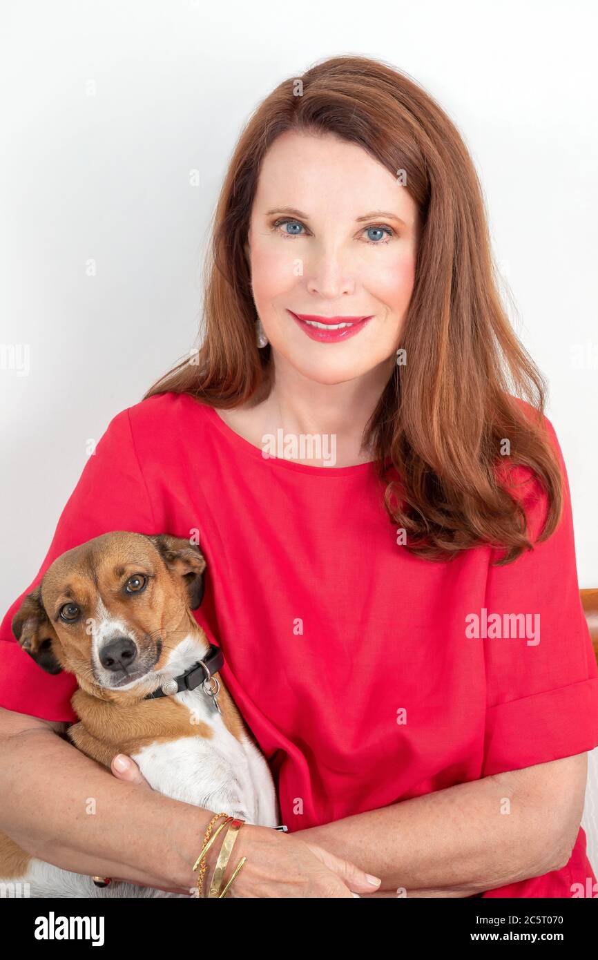 Sitzende Frau posiert mit ihrem Hund Stockfoto