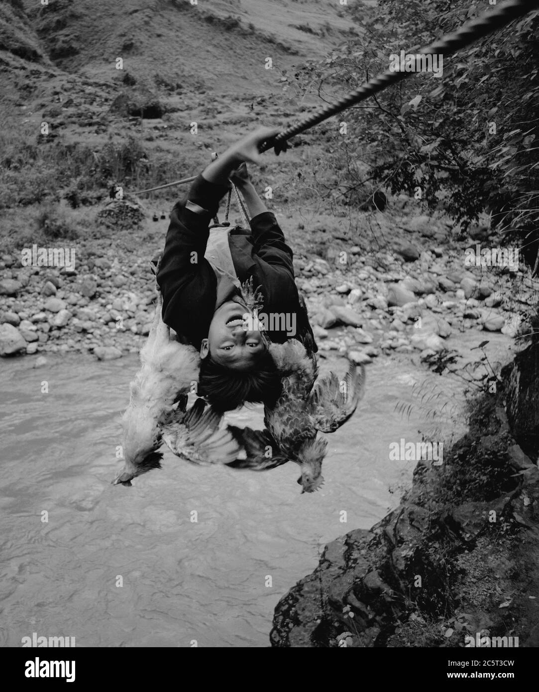 Butuo. Juli 2020. Das am 21. März 2006 aufgenommene Foto zeigt einen Dorfbewohner, der mit einem Kabel am Xixi Fluss im Dorf Abuluoha, südwestlich der Provinz Sichuan, vorbeikommt. UM MIT XINHUA SCHLAGZEILEN VOM 5. JULI 2020 zu GEHEN Quelle: Lin Qiang/Xinhua/Alamy Live News Stockfoto
