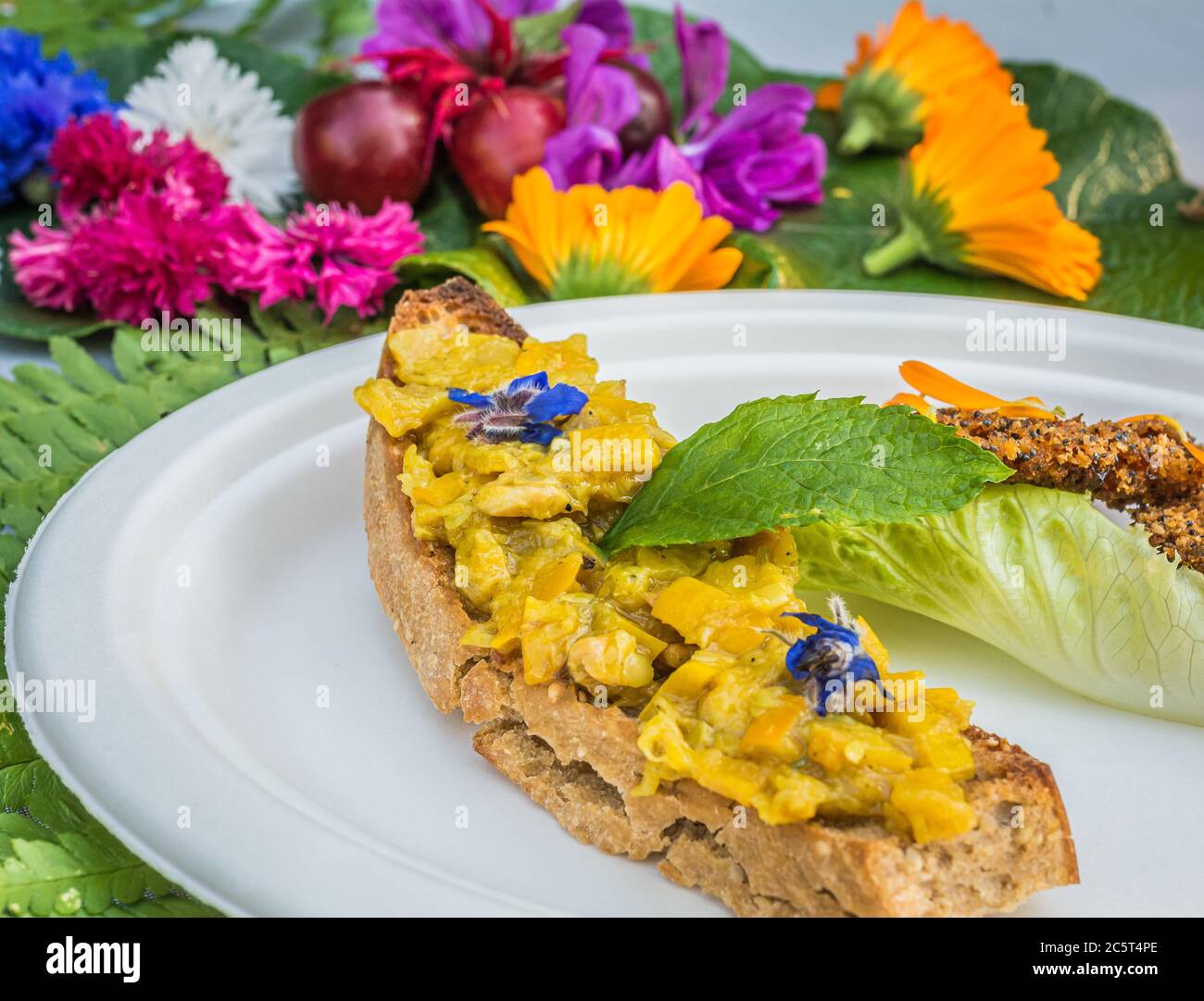 Vorspeise mit Ringelblumen und Crouton. Teller mit frischen Blumen verziert. Blumenfutter Konzept. Essbare Sommerblumen Stockfoto