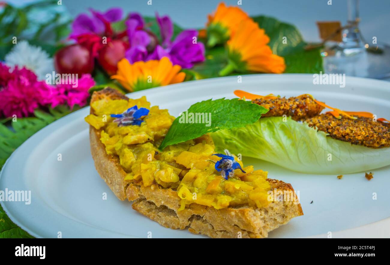 Vorspeise mit Ringelblumen und Crouton. Teller mit frischen Blumen verziert. Blumenfutter Konzept. Essbare Sommerblumen Stockfoto