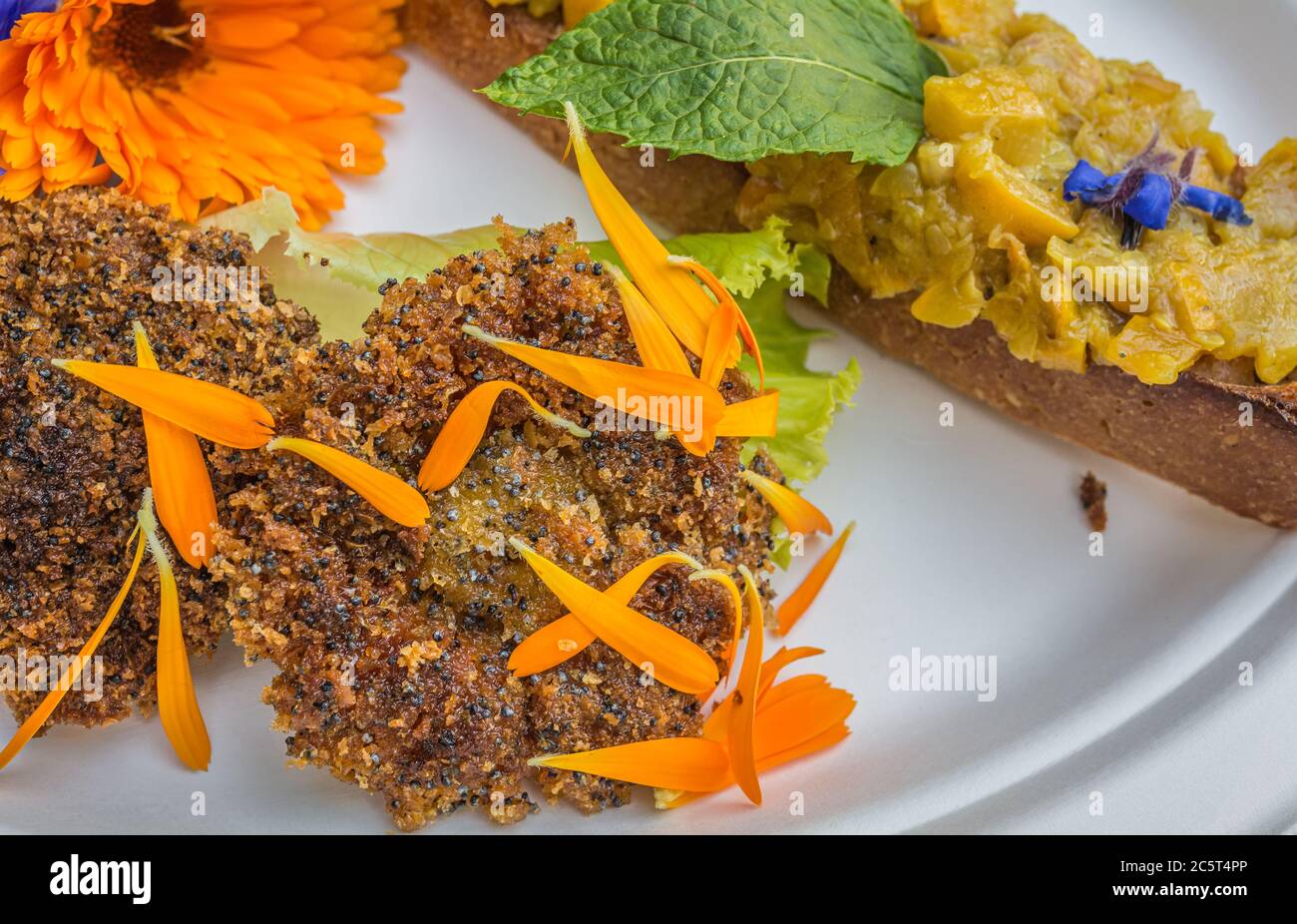 Vorspeise mit Ringelblumen und Crouton. Teller mit frischen Blumen verziert. Blumenfutter Konzept. Essbare Sommerblumen Stockfoto