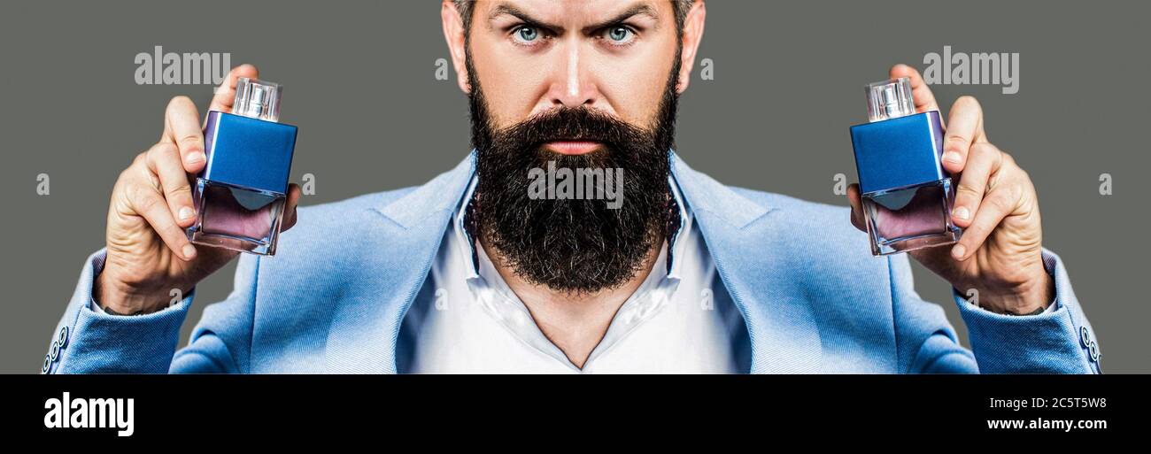 Maskulines Parfüm, bärtiger Mann in einem Anzug. Parfüm oder köln Flasche und Parfümerie, Kosmetik, Duft köln Flasche, männlich Holding köln. Maskulin Stockfoto