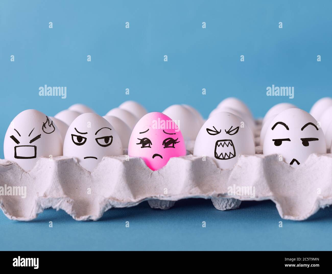 Das seltsame, Gesichter auf den Eiern, Nein zu Rassismus, Diskriminierungskonzept mit blauem Hintergrund Stockfoto