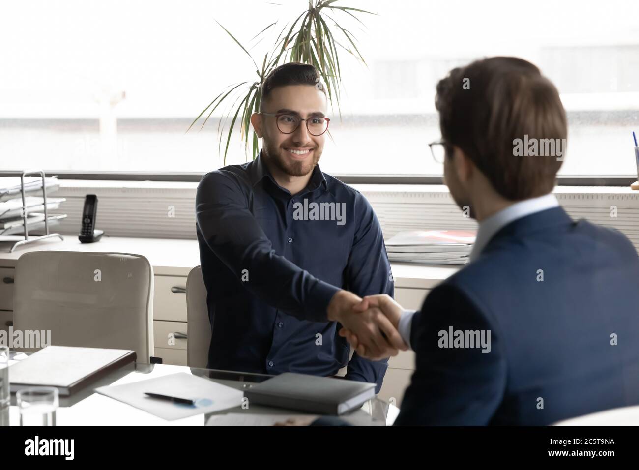 Lächelnd arabischer Geschäftsmann Handshake männlichen Partner bei Büromeeting Stockfoto