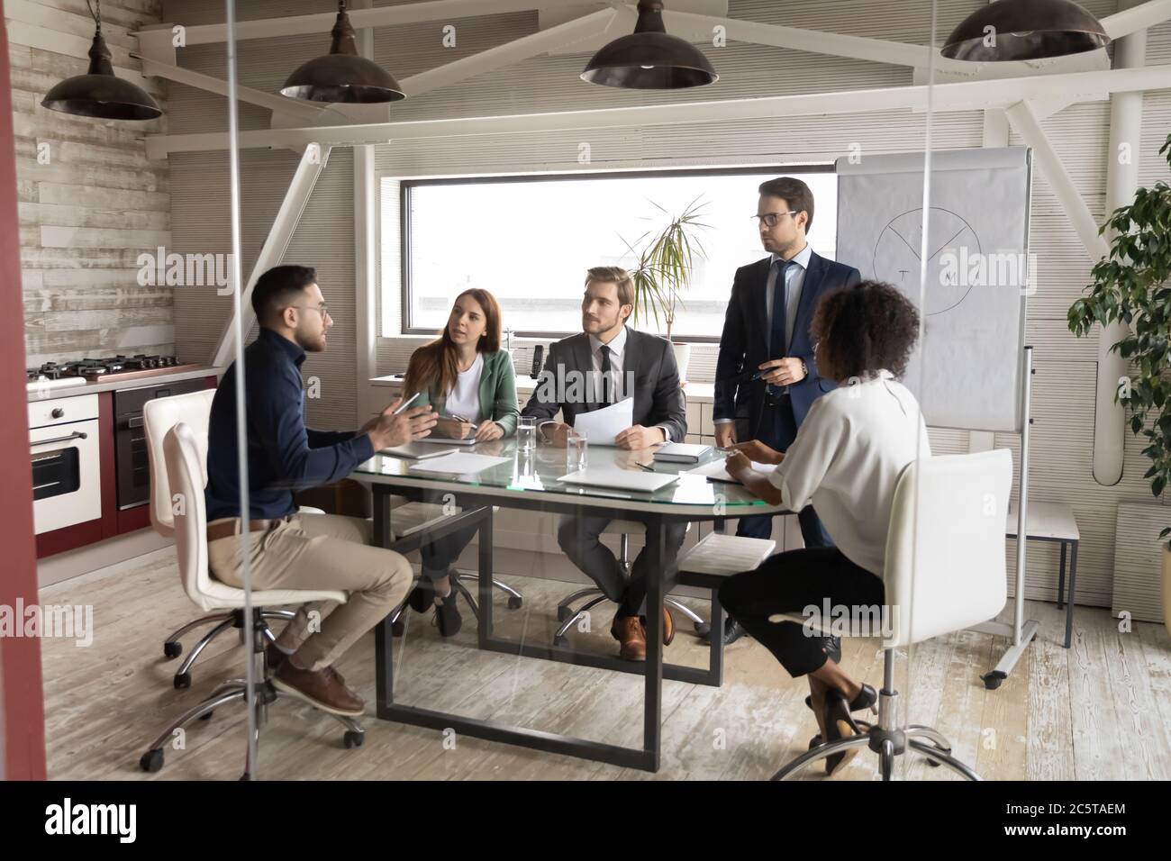 Junge, multirassische Geschäftsleute führen bei Teambesprechung im Sitzungssaal ein Brainstorming durch Stockfoto