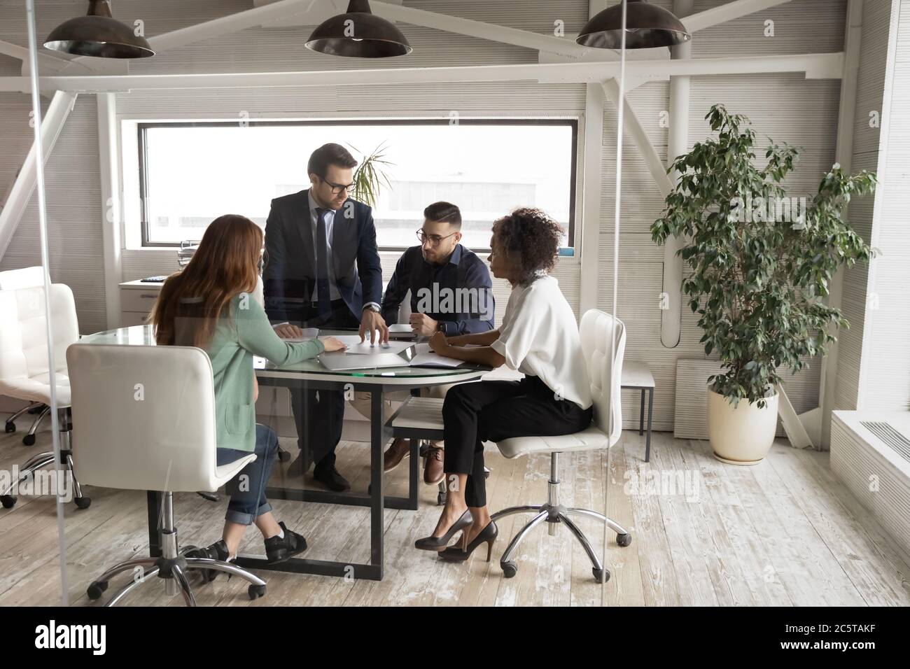 Bei Teambesprechung im Sitzungssaal treffen sich seriöse, multiethnische Geschäftsleute Stockfoto