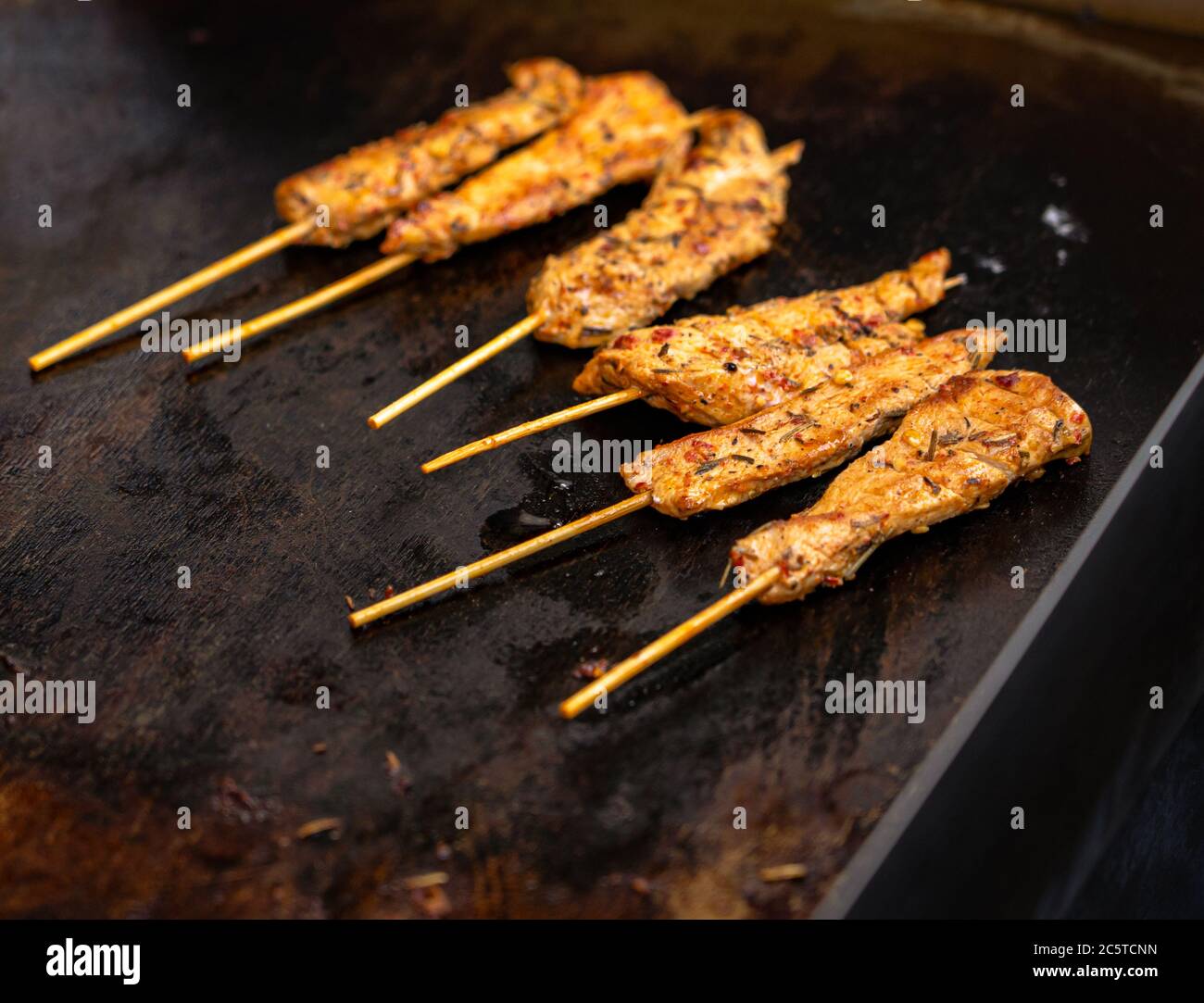 Nahaufnahme von Chicken Satay, das auf einem Grillrost im Restaurant zubereitet wird Stockfoto