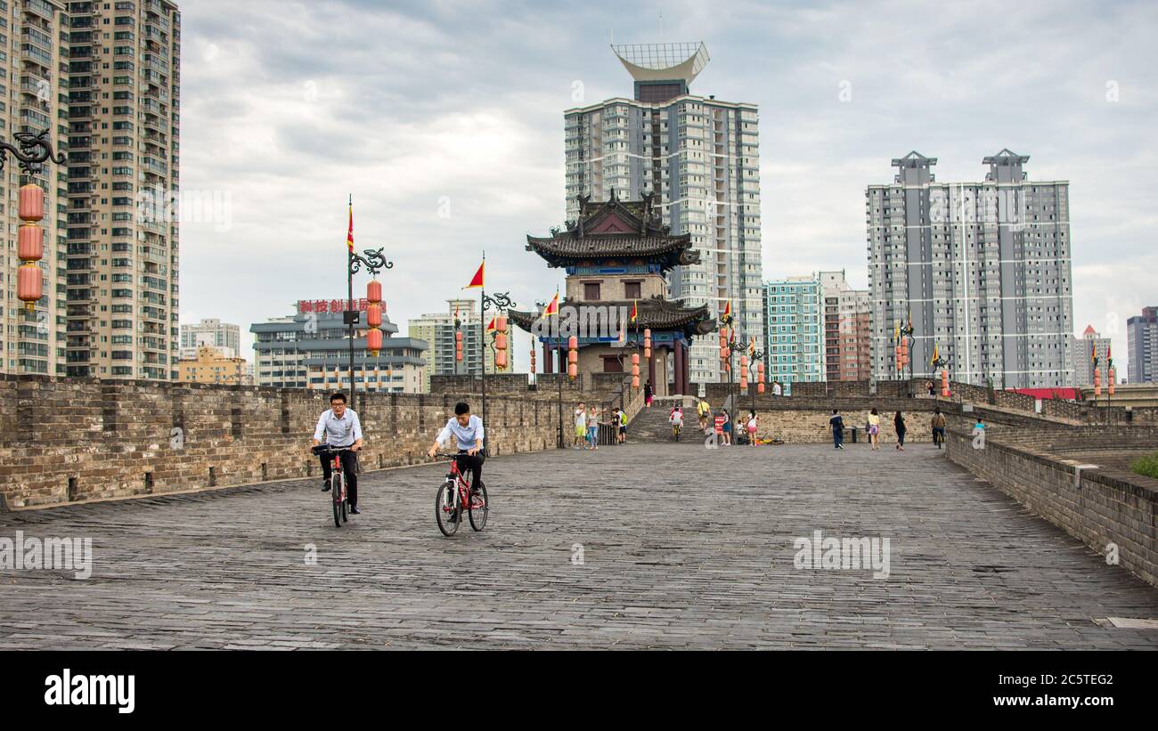 Xian, Provinz Shaanxi / China - 4. August 2015: Menschen fahren Fahrräder auf der größten und am besten erhaltenen alten Stadtmauer von Xian Stockfoto