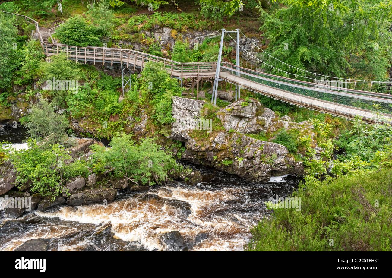 ROGIE FALLS RIVER BLACK WATER ROSS-SHIRE HIGHLANDS SCHOTTLAND IM SOMMER DIE HÄNGEBRÜCKE UND DER GEHWEG ÜBER DIE UNTEREN WASSERFÄLLE Stockfoto