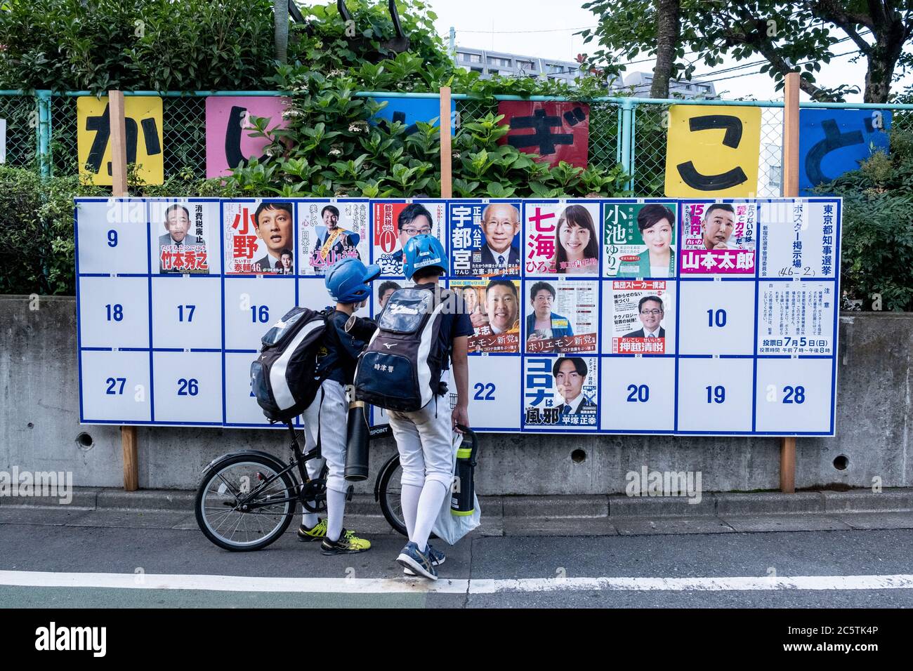 Jugendliche schauen sich ein Wahlboard mit verschiedenen Kandidaten-Plakaten an.Tokyo hält Gouverneurswahlen ab 2020 heute stimmen die Einwohner Tokios für den nächsten Gouverneur, der die japanische Hauptstadt für die kommenden vier Jahre anführt. Stockfoto