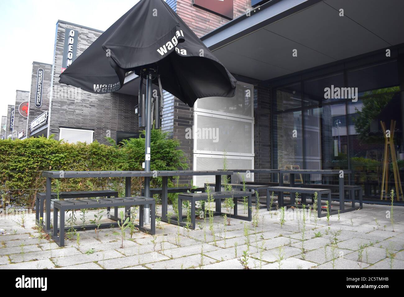 Unkraut bei Wagamama! Während der Covid-19 lockdonw haben Unkraut den Outdoor-Essbereich in Wagamama im MK1 Shopping Park, Milton Keynes, übernommen. Stockfoto