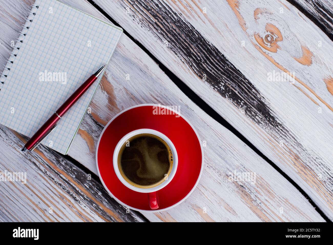 Topview leerer Keramikbecher und Notizblock mit einem Stift. Stockfoto