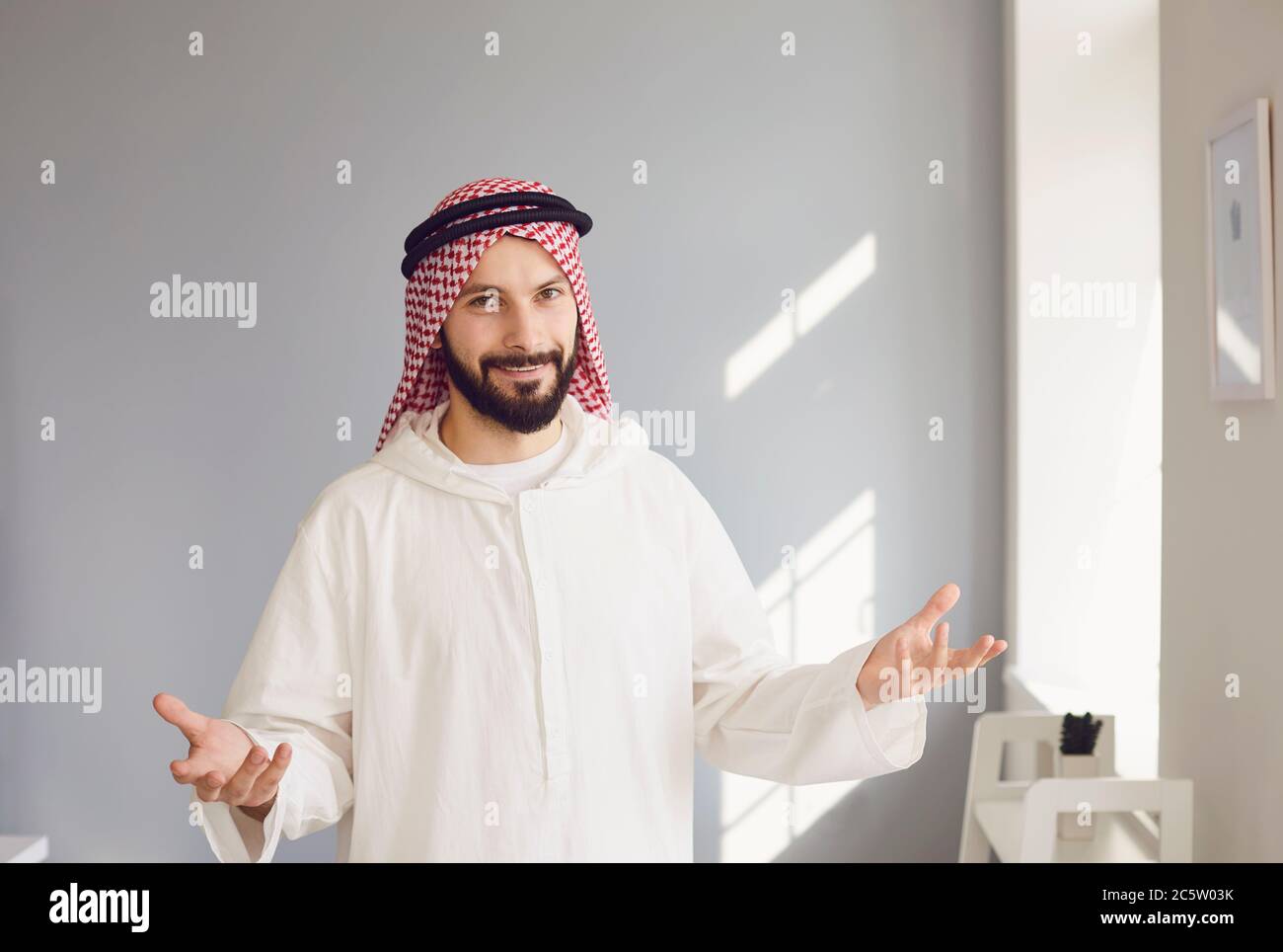 Arabischer männlicher Geschäftsmann lächelndes Porträt, das auf grauem Hintergrund steht Stockfoto