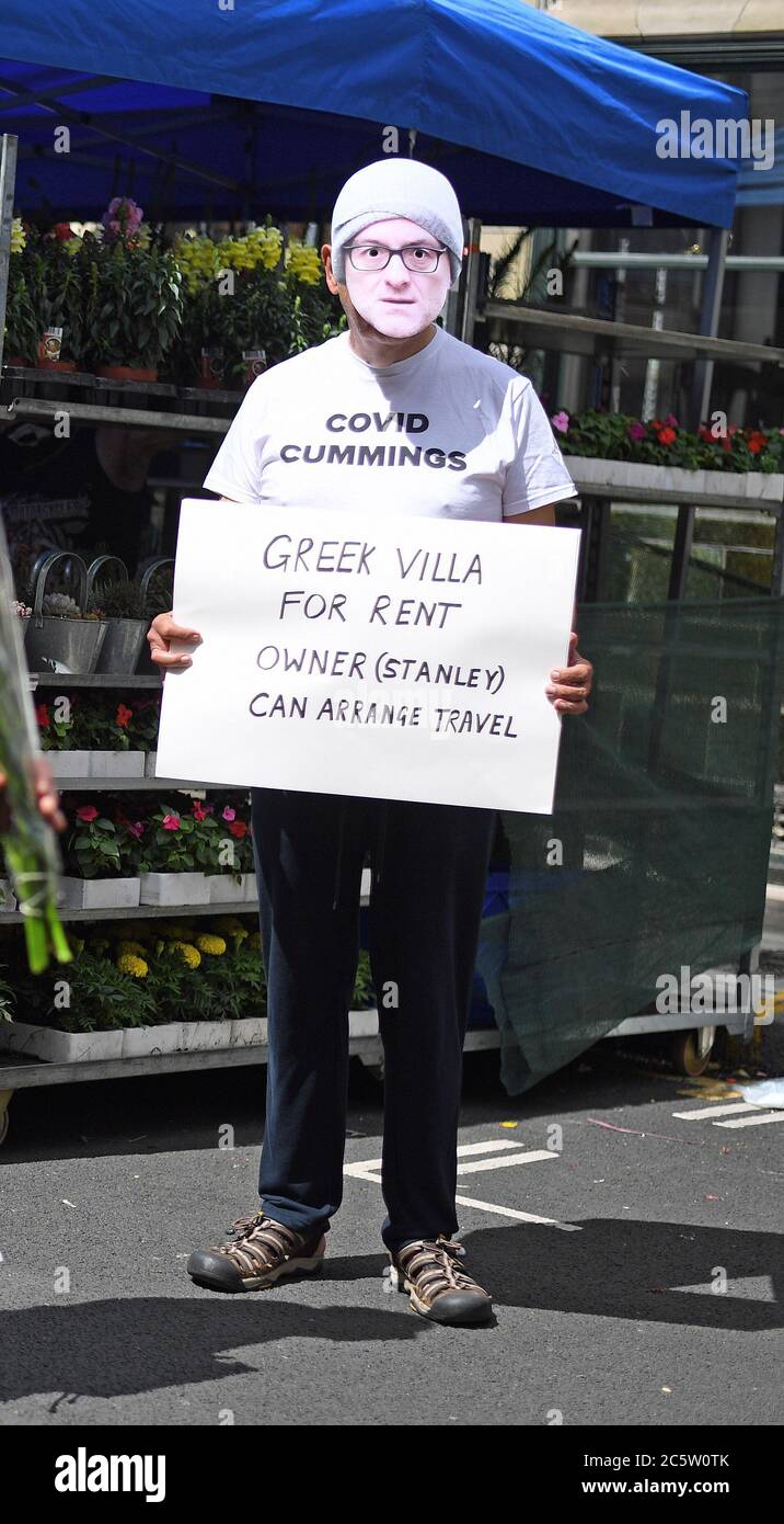 Ein Mann in einer Dominic Cummings Maske auf dem Columbia Road Flower Market, London, als er nach der Lockerung der Coronavirus-Sperrbeschränkungen in ganz England wieder eröffnet wird. Stockfoto