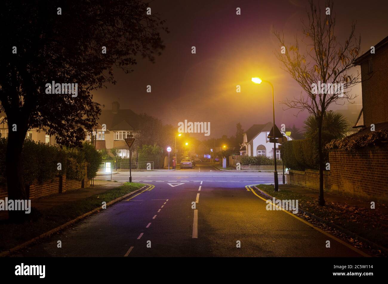 Leere Straßen von Laternen in der Nacht mit Streifen beleuchtet Leicht Stockfoto