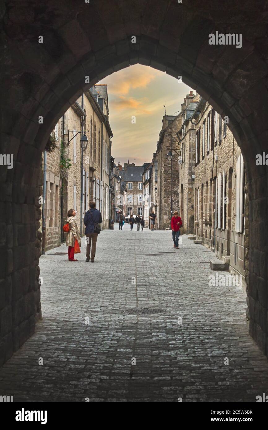 Dinan, Bretagne, Frankreich. Alte gepflasterte Straße, die zur Porte de Saint Malo und den befestigten Mauern führt. Stockfoto