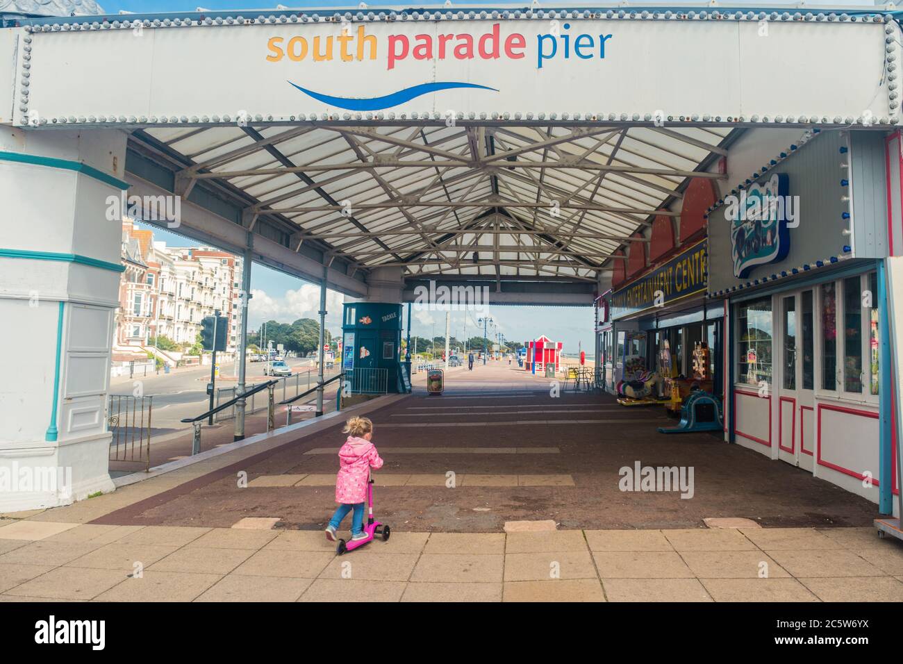 Ein kleines Mädchen auf einem Roller neben South Parade Pier, Southsea, Hampshire, England, Großbritannien Stockfoto