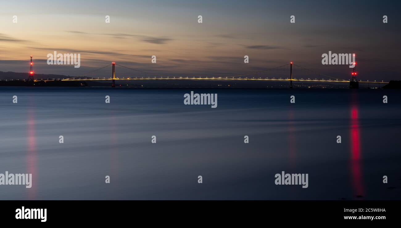 Ein Nachglühen des Sonnenuntergangs hängt über der Severn Bridge und dem Flussmündungsgebiet von Severn in Gloucestershire. Stockfoto