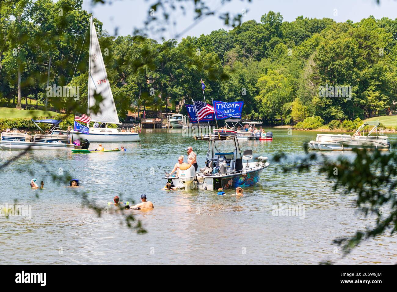 Mooresville, NC, USA - 4. Juli 2020: Boote, die Trump 2020 Flaggen für Präsident Donald Trump auf dem Norman See in der Nähe des Trump National Golf Club Charlot fliegen Stockfoto