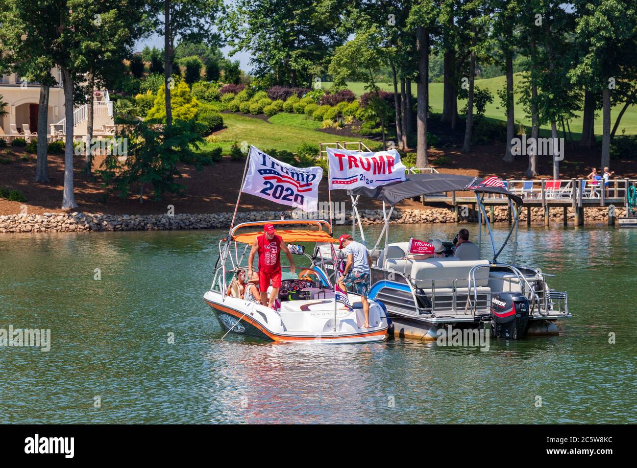 Mooresville, NC, USA - 4. Juli 2020: Boote, die Trump 2020 Flaggen für Präsident Donald Trump auf dem Norman See in der Nähe des Trump National Golf Club Charlot fliegen Stockfoto