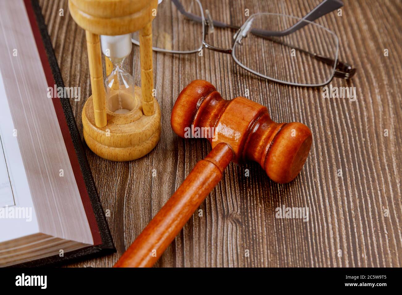 Öffnen Sie das Gesetzbuch mit einem hölzernen Richter Gavel auf dem Tisch in einem Gerichtssaal oder Strafverfolgungsbehörde Justizsymbol, Rechtsgesetz Konzept Stockfoto