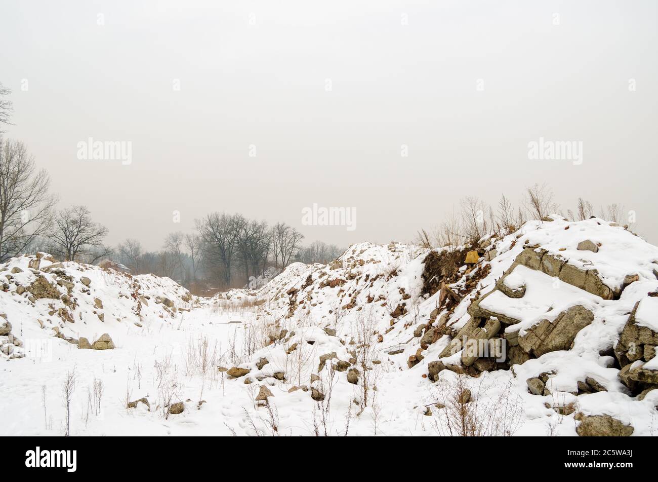 Ein Pfad zwischen Trümmern, die im Winter mit Schnee übersät sind Stockfoto