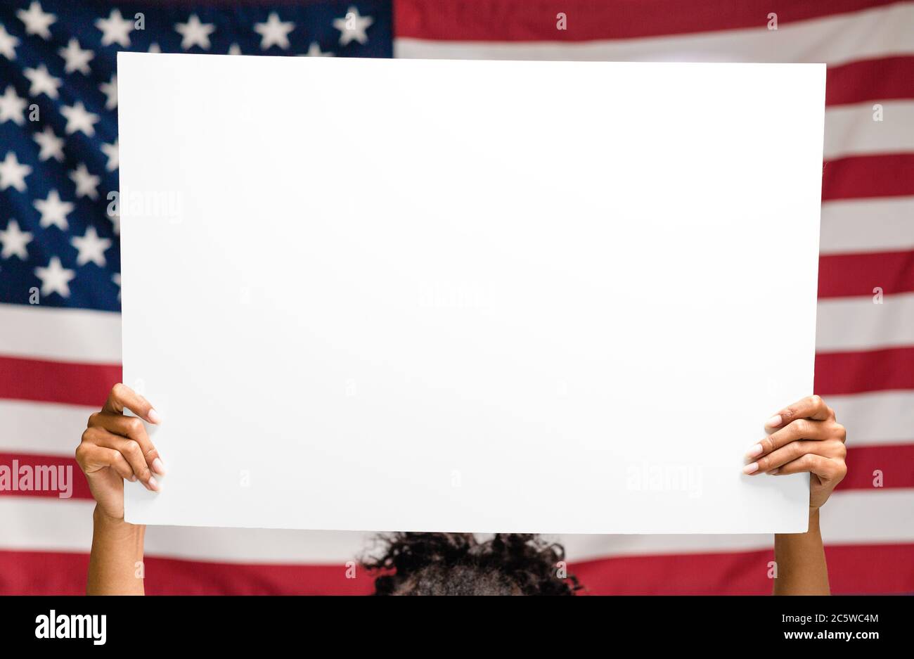 Leeres Poster für Text in Händen über US-Flagge, leerer Raum Stockfoto
