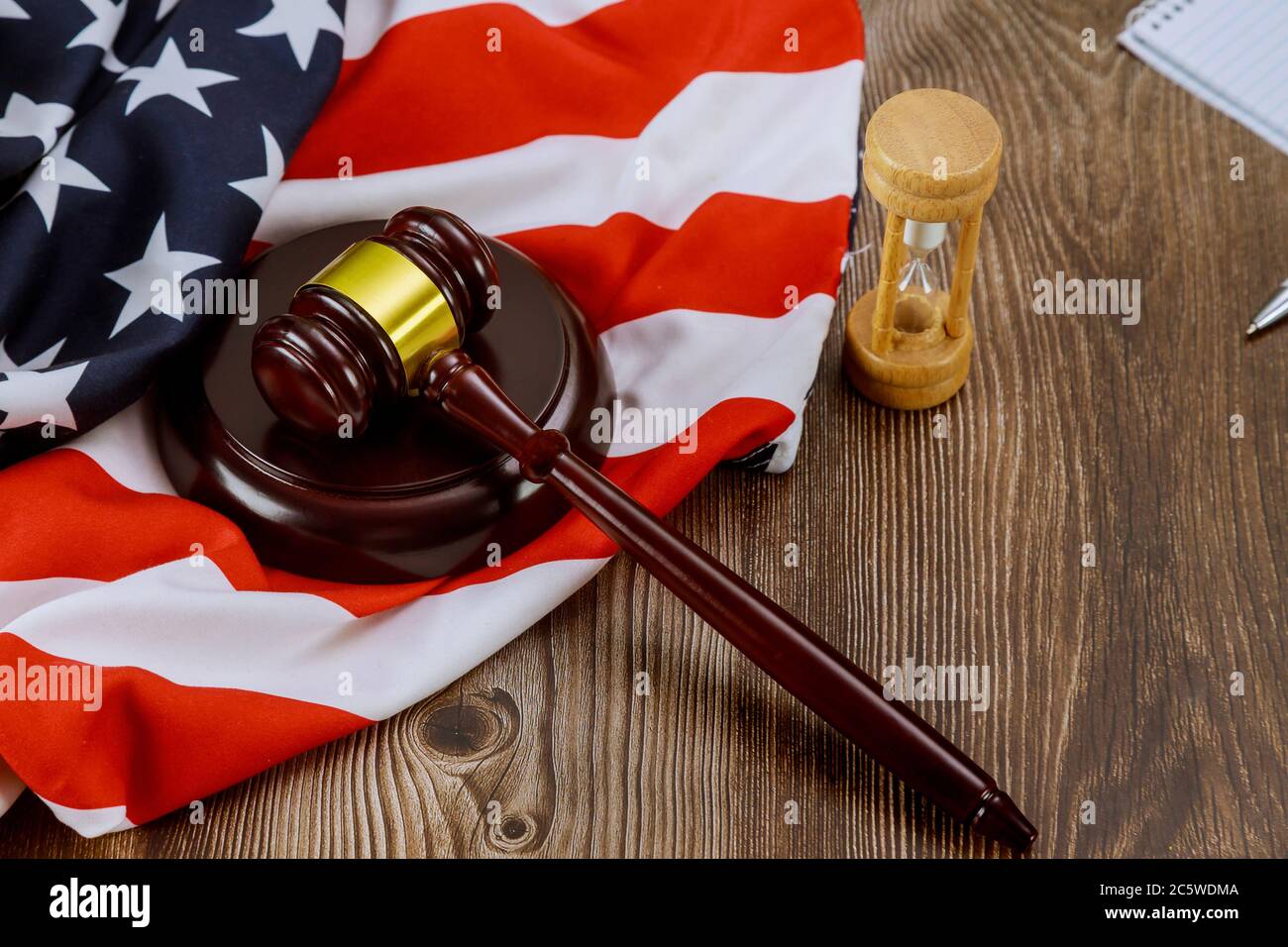 Hourglass misst das US-Richterrechtsamt mit Richtergavel auf amerikanischem Flaggenholztisch Stockfoto