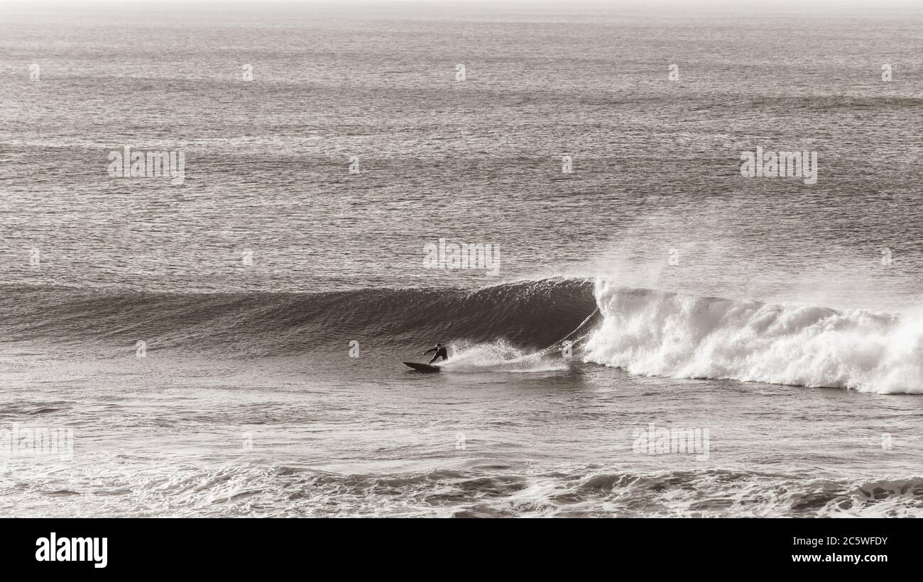 Surfer Surfen unten Drehen auf Meereswelle in vintage Sepia Ton mit Blick auf Panorama-Foto. Stockfoto