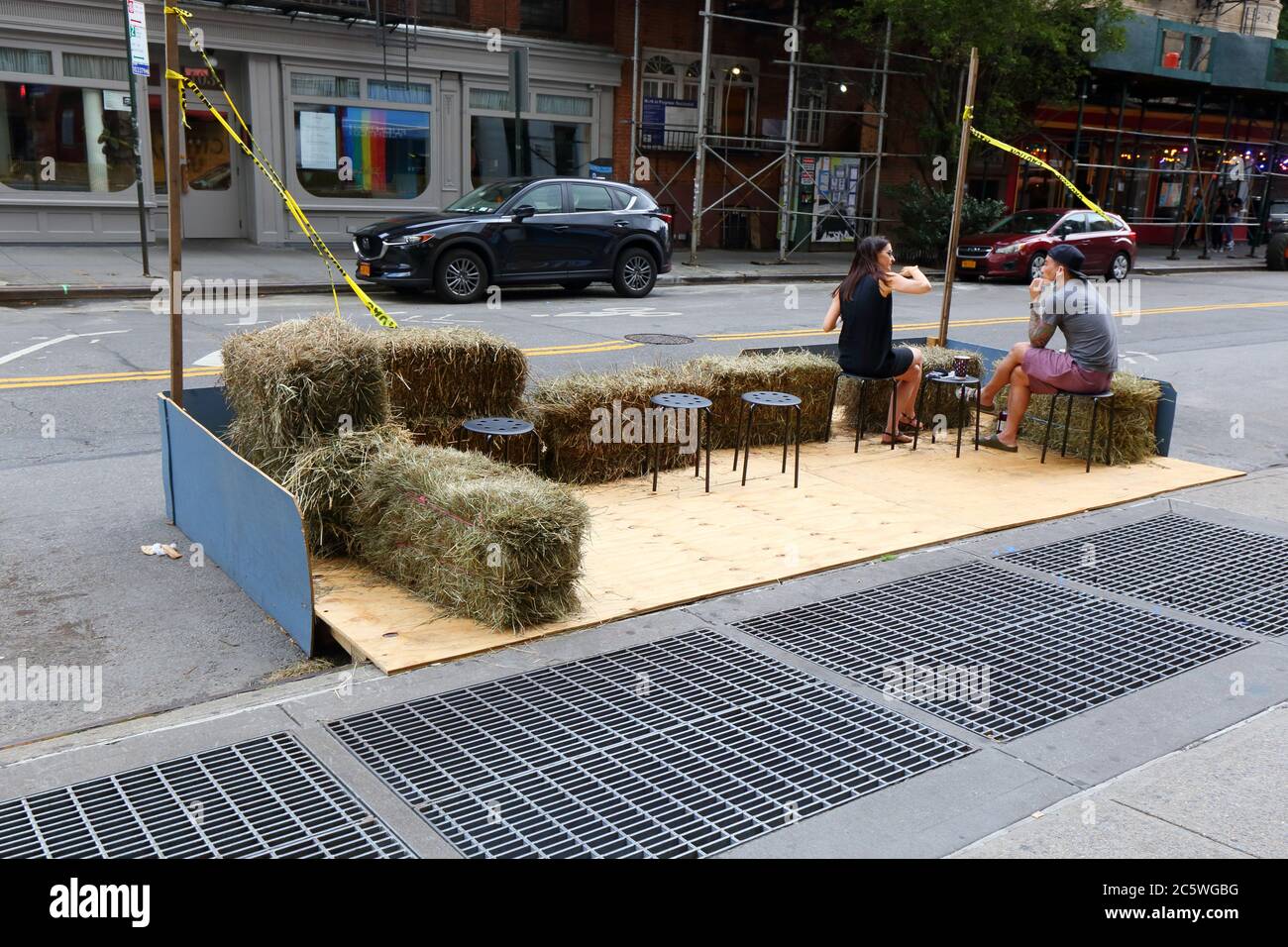 Ein mit Heuballen und Hockern eingerichteter Park für gesellschaftlich distanziertes Essen im Freien an einer Bar im Greenwich Village in Manhattan Stockfoto
