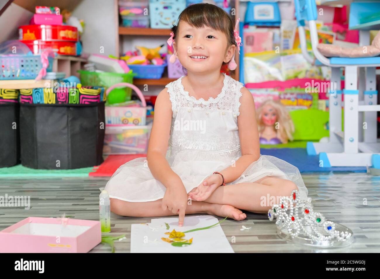 Kind kleines Mädchen spielen Spielzeug ungeordnete Chaos im Wohnzimmer ein schmutziger oder unordentlich Zustand von Spielzeug und Puppe zu Hause Stockfoto