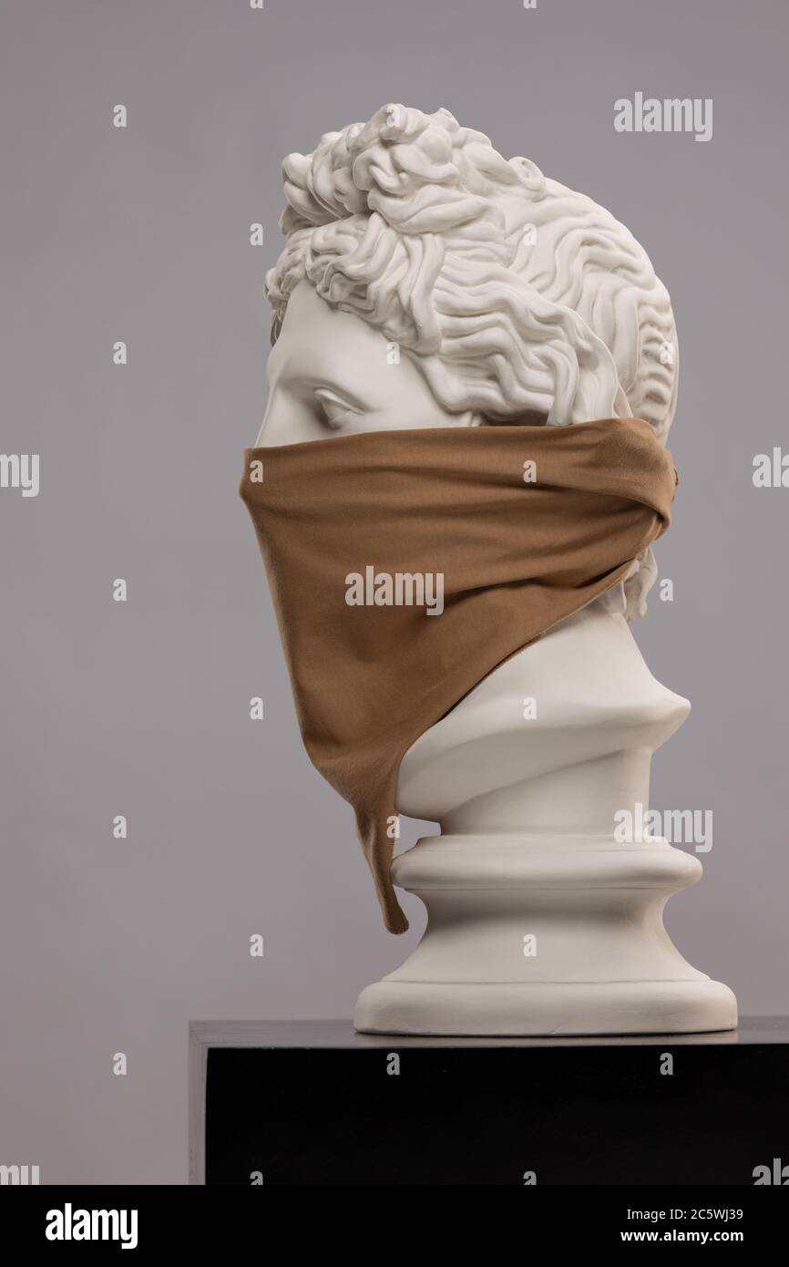 Weiße Gipsstatue einer Büste von Apollo Belvedere in einem Kopftuch, das sein Gesicht bedeckt Stockfoto
