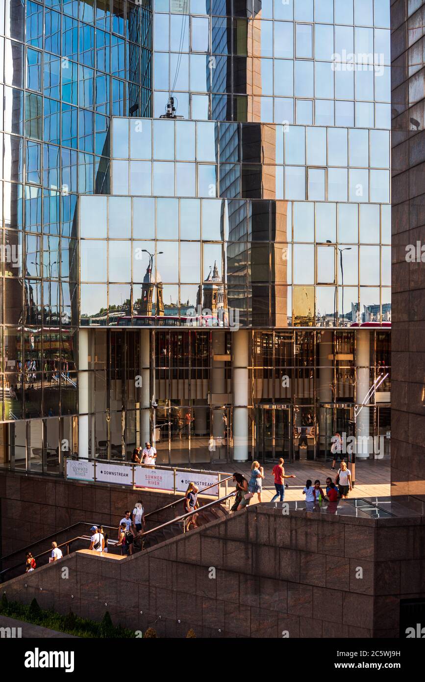 Zufällige Menschen und Touristen in Central London, in der Nähe der Themse an einem hohen Spiegel wie Bürogebäude Stockfoto