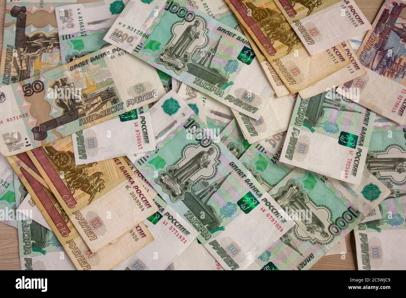 Geld, russische Banknoten verschiedener Konfessionen sind auf dem Tisch verstreut. Stockfoto