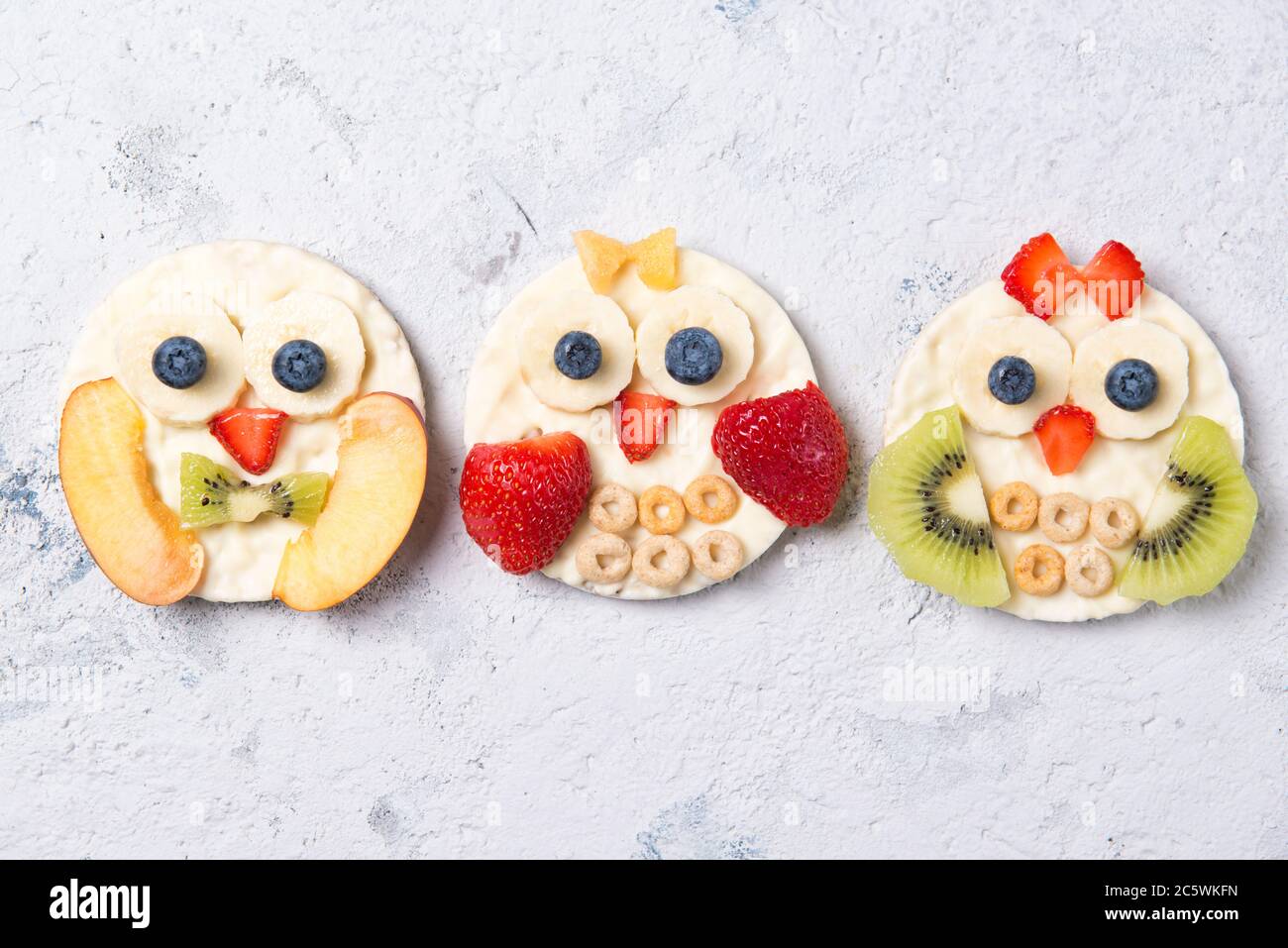 Reiskuchen mit Joghurt und frischem Obst in Formen von niedlichen Eulen, Mahlzeit für Kinder Idee, Draufsicht Stockfoto
