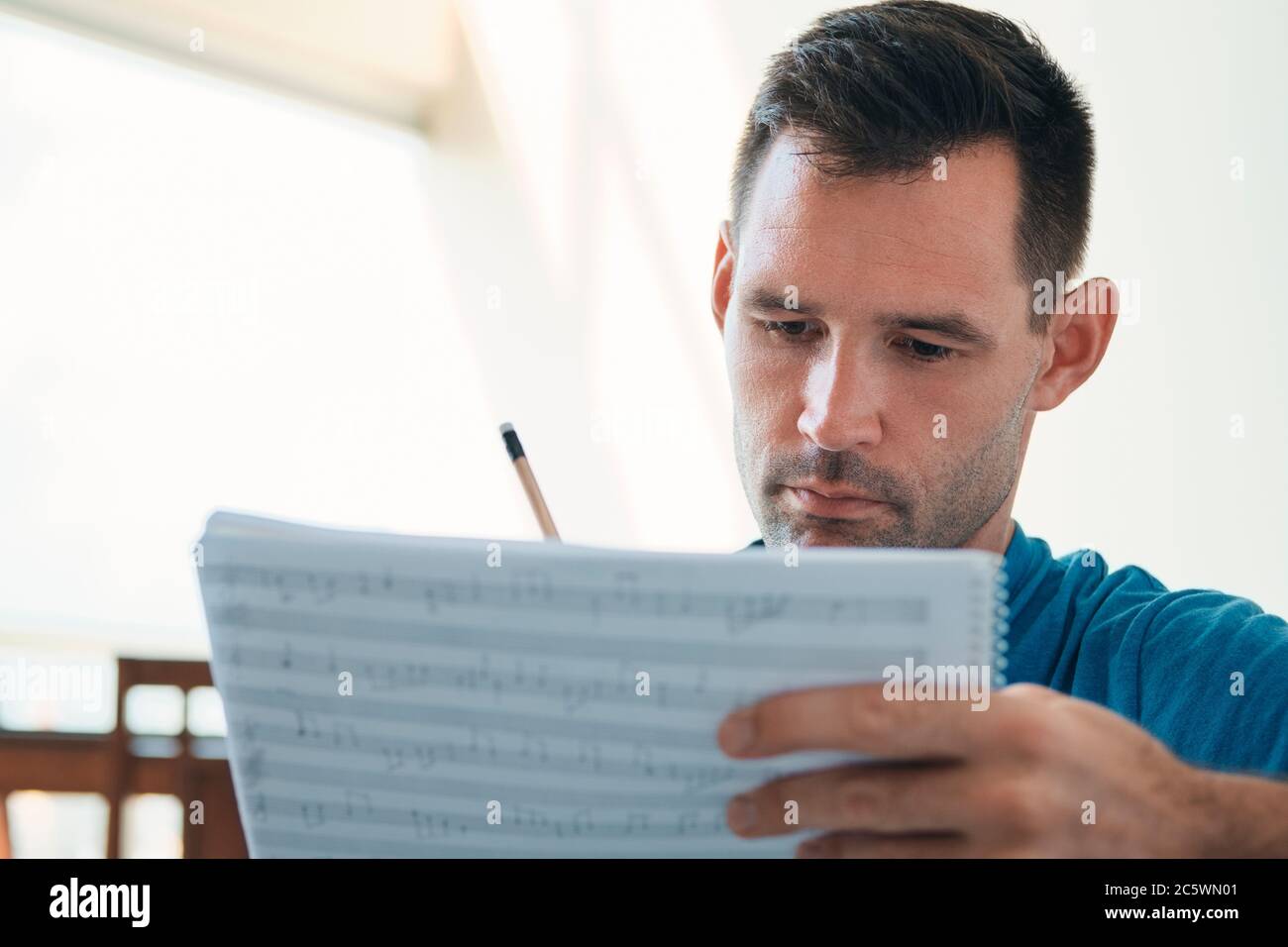 Mann Komponiert Musik Mit Notenblättern, Um Notizen Zu Schreiben Stockfoto