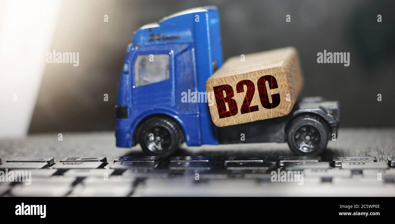 Holzblock mit B2C Abkürzung auf Spielzeugauto. Business-to-Customer-Konzept. Stockfoto