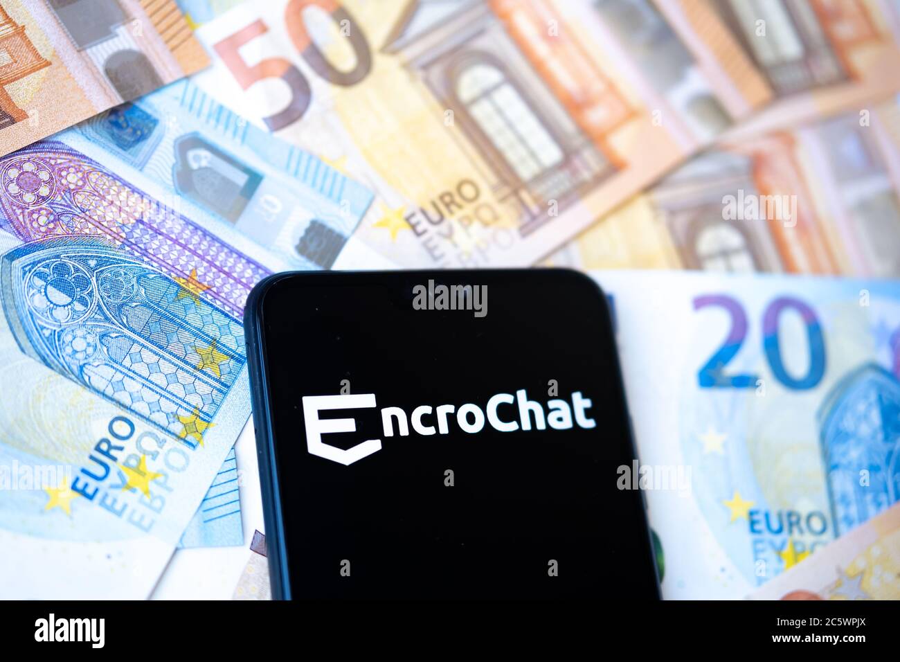 Stone / UK - 5. Juli 2020: EncroChat Logo auf dem Smartphone und verbreiten Haufen von Euro. Selektiver Fokus. Stockfoto