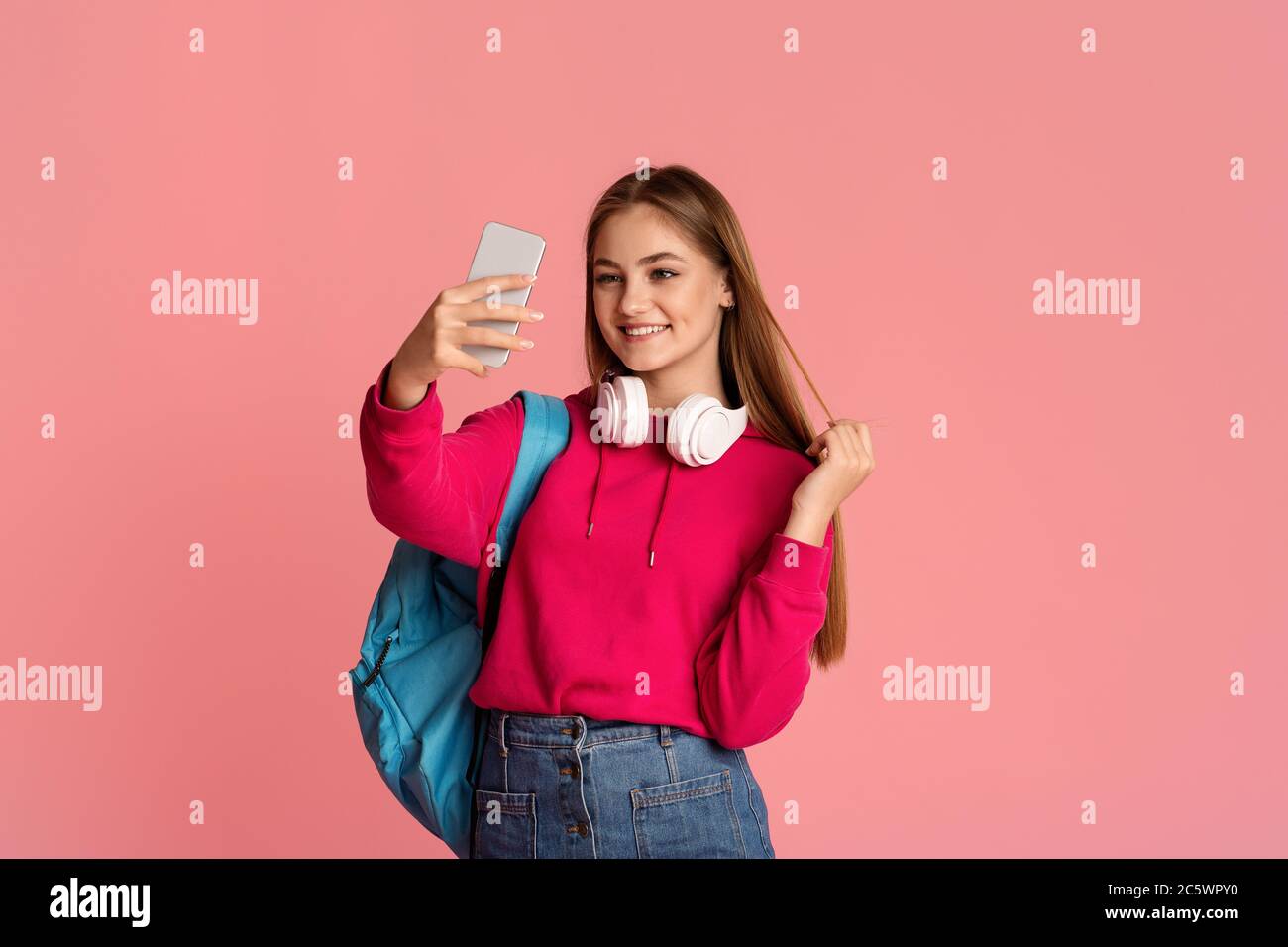 Teen Mädchen macht Selfie auf rosa Hintergrund Stockfoto