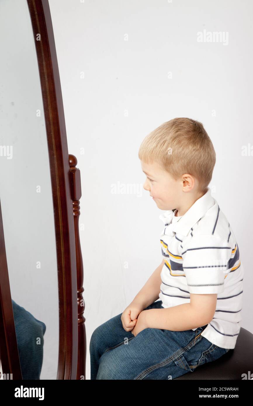 Cute blonde junge suchen in einem Spiegel Stockfotografie - Alamy