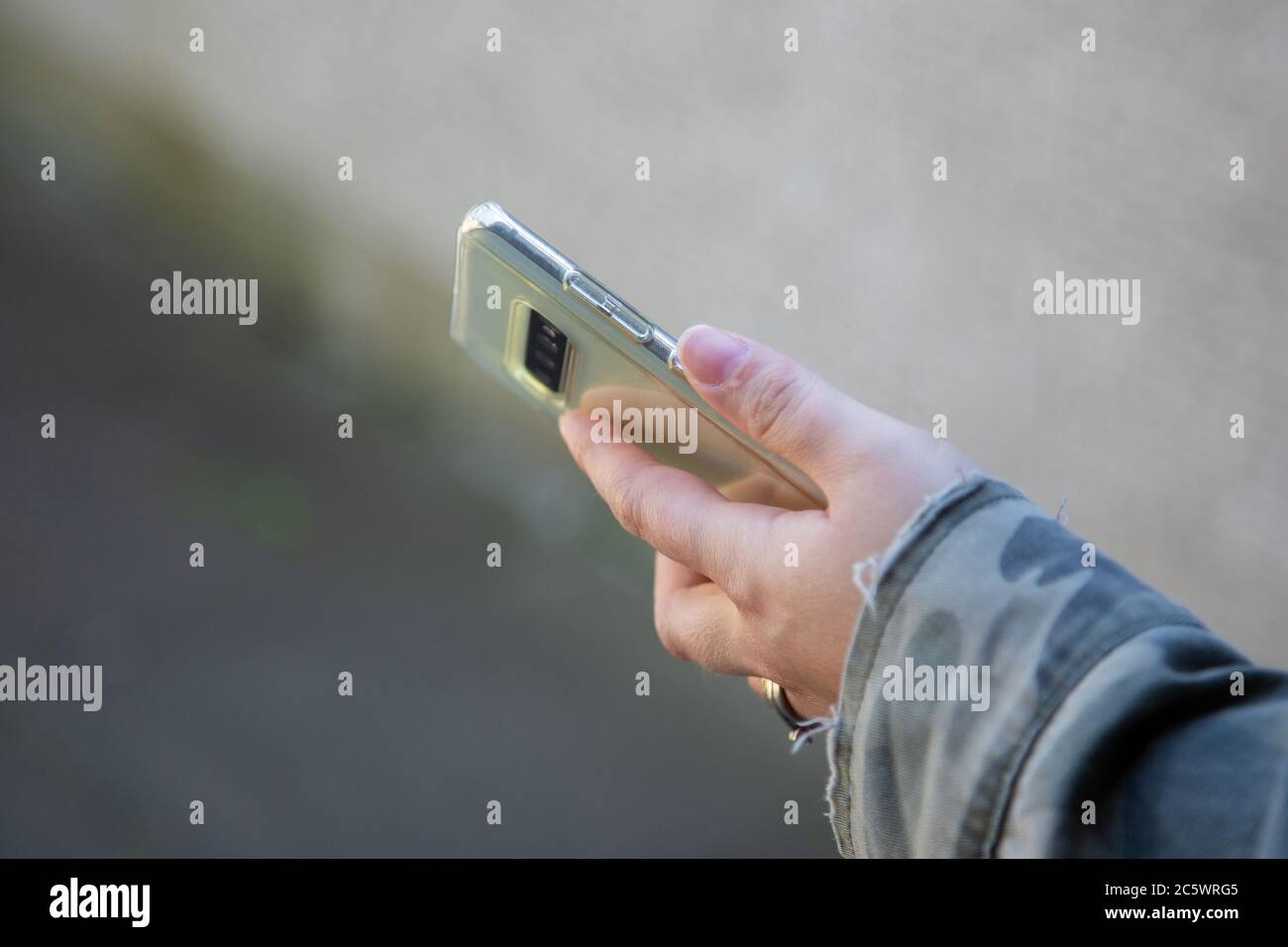 Die Hand einer Frau, die ein Mobiltelefon oder Mobiltelefon hält Stockfoto