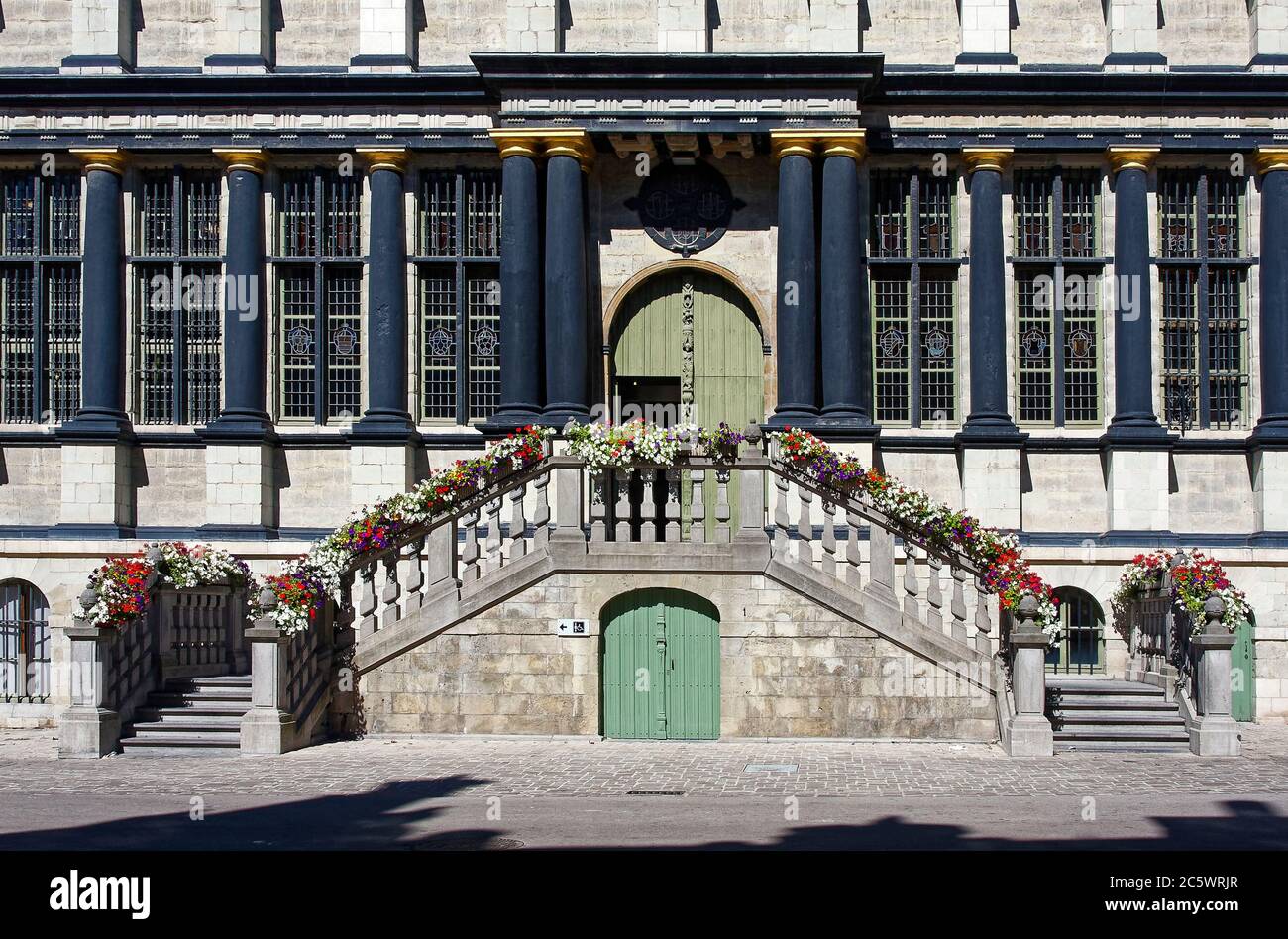 Rathaus, Stadhuis; Renaissance-Fassade, 17. Jahrhundert, viele Fenster, schwarze Säulen, gewölbte Türen, zweiseitige Stufen, Blumen auf Steingeländer, Flandern Stockfoto